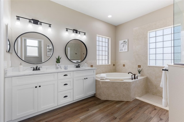 1044 SW 159th St, Ocala, FL 34473 - bathroom featuring double vanity, plenty of natural light, wood finished floors, and a bath