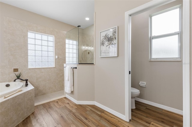 1044 SW 159th St, Ocala, FL 34473 - bathroom featuring wood finished floors, walk in shower, a garden tub, and toilet