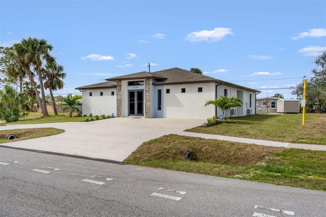 5479 S Biscayne Dr, North Port, FL 34287 - view of front of home featuring stucco siding, a front yard, concrete driveway, and stone siding