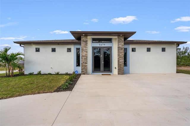 5479 S Biscayne Dr, North Port, FL 34287 - view of front facade with stucco siding, stone siding, and a front yard