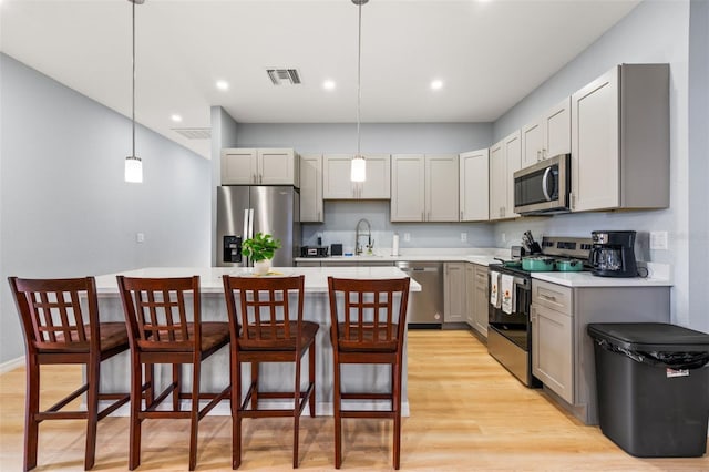 5479 S Biscayne Dr, North Port, FL 34287 - kitchen with stainless steel appliances, gray cabinets, light wood-style floors, light countertops, and recessed lighting