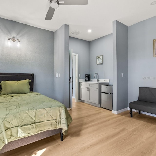 5479 S Biscayne Dr, North Port, FL 34287 - bedroom featuring freestanding refrigerator, light wood finished floors, baseboards, a ceiling fan, and a sink