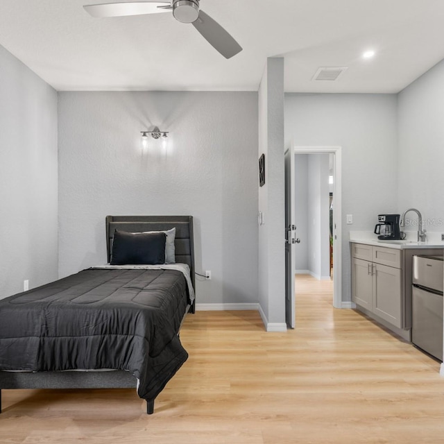 5479 S Biscayne Dr, North Port, FL 34287 - bedroom with a sink, light wood-type flooring, freestanding refrigerator, baseboards, and a ceiling fan