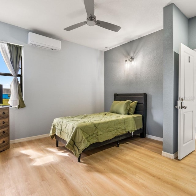 5479 S Biscayne Dr, North Port, FL 34287 - bedroom with a wall mounted AC, light wood-style flooring, and baseboards