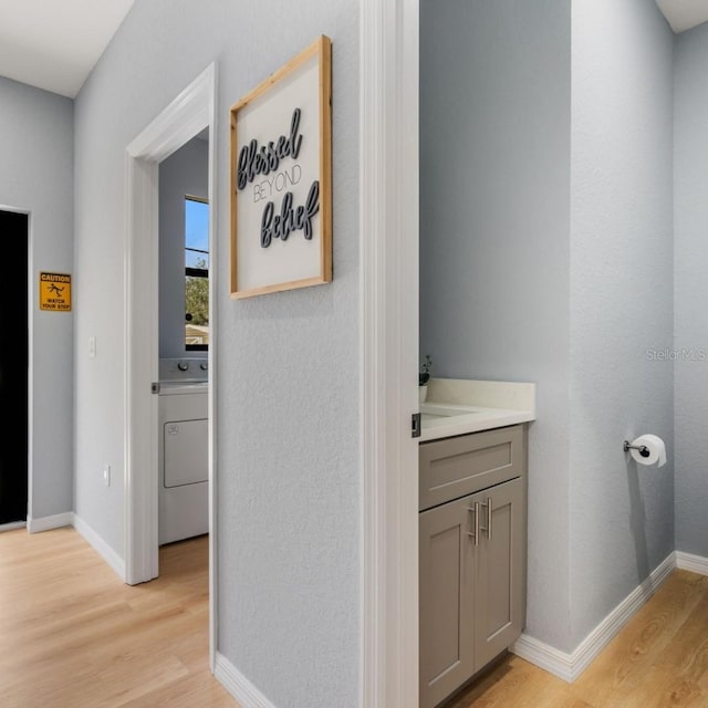 5479 S Biscayne Dr, North Port, FL 34287 - hall with washer / clothes dryer, light wood-style floors, and baseboards