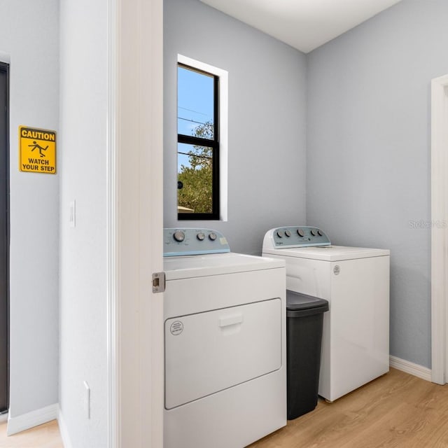5479 S Biscayne Dr, North Port, FL 34287 - laundry area with washer and dryer, light wood-type flooring, and baseboards