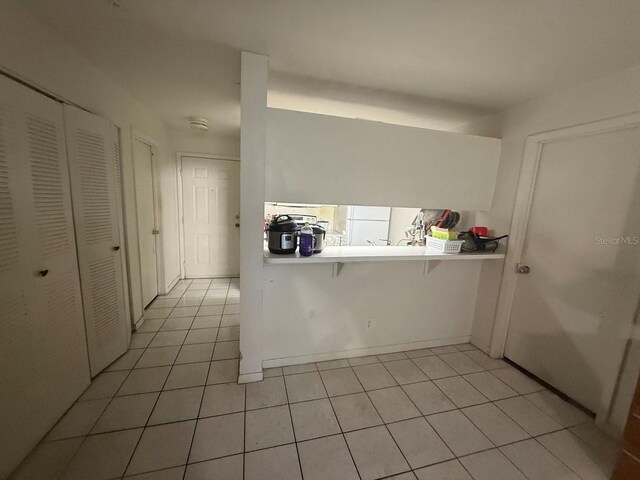 3800 SW 20th Ave Unit 611, Gainesville, FL 32607 - kitchen with light tile patterned flooring, light countertops, and a breakfast bar area