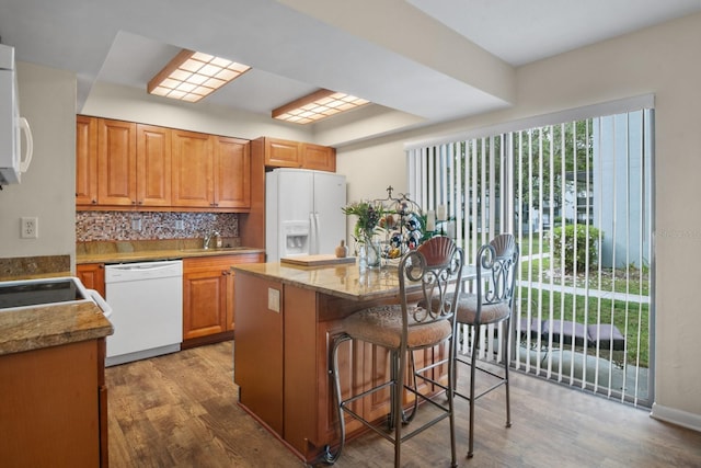 401 NW 39th Rd Unit 401C, Gainesville, FL 32607 - kitchen featuring white appliances, a sink, wood finished floors, and a breakfast bar