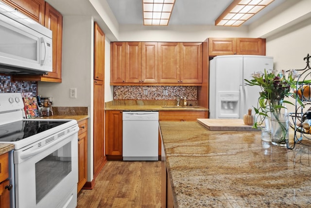 401 NW 39th Rd Unit 401C, Gainesville, FL 32607 - kitchen featuring white appliances, a sink, light wood finished floors, decorative backsplash, and brown cabinets