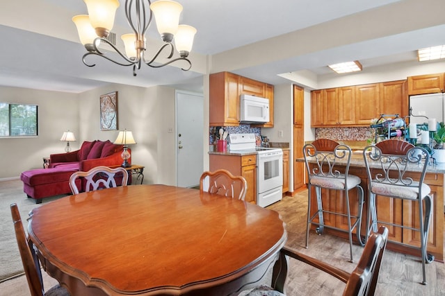 401 NW 39th Rd Unit 401C, Gainesville, FL 32607 - dining room with light wood finished floors and a chandelier