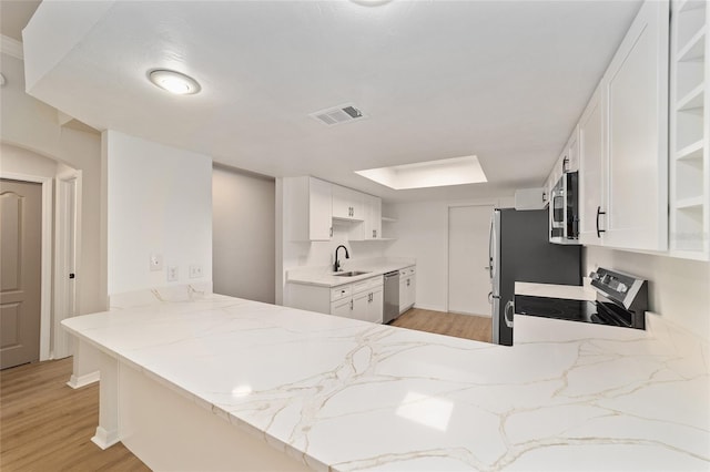 6245 NW 106th Pl Unit 6245, Alachua, FL 32615 - kitchen featuring open shelves, stainless steel appliances, light wood-style floors, and light stone counters