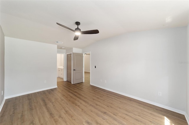 6245 NW 106th Pl Unit 6245, Alachua, FL 32615 - unfurnished bedroom with baseboards, light wood-style floors, vaulted ceiling, and ensuite bathroom
