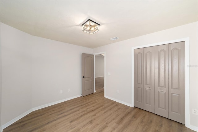 6245 NW 106th Pl Unit 6245, Alachua, FL 32615 - unfurnished bedroom with baseboards, wood finished floors, and a closet