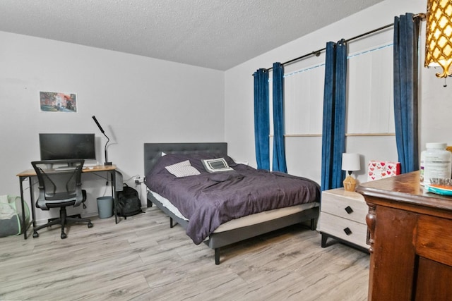 2811 SW Archer Rd Unit O123, Gainesville, FL 32608 - bedroom featuring wood finished floors, a textured ceiling, and an office area