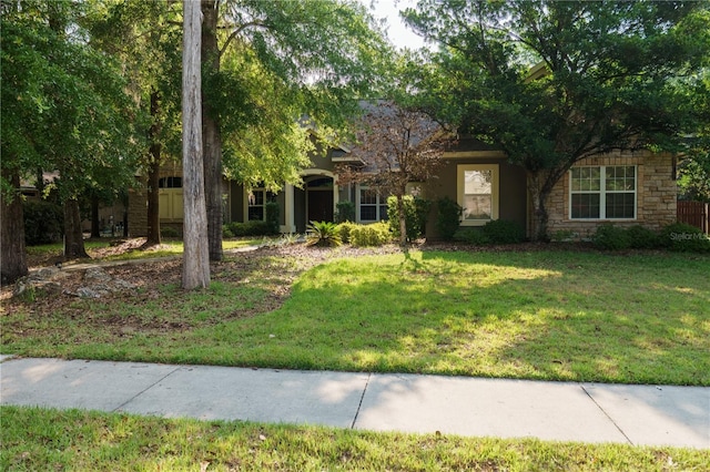5119 NW 57th St, Gainesville, FL 32653 - obstructed view of property featuring stone siding and a front lawn