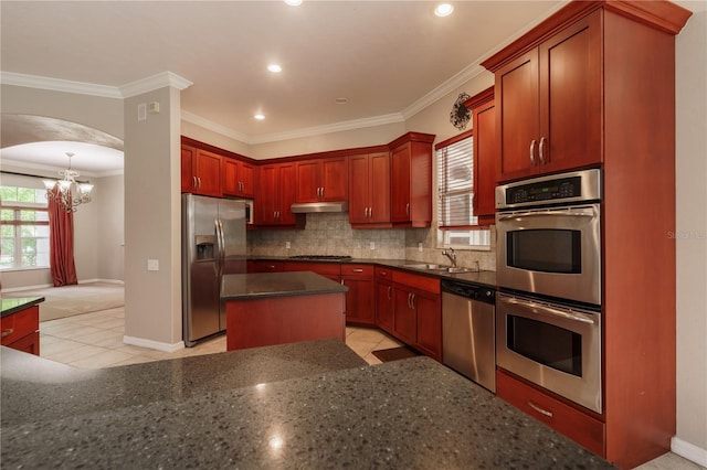 5119 NW 57th St, Gainesville, FL 32653 - kitchen featuring stainless steel appliances, a chandelier, under cabinet range hood, decorative backsplash, and a sink