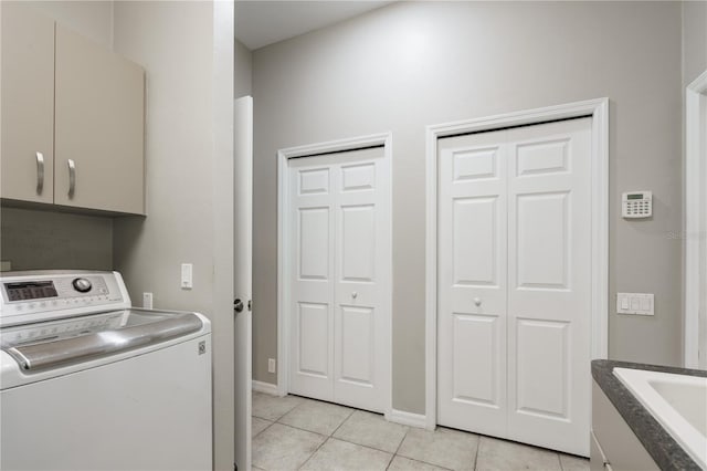 5119 NW 57th St, Gainesville, FL 32653 - laundry room with washer / dryer, cabinet space, light tile patterned floors, and baseboards