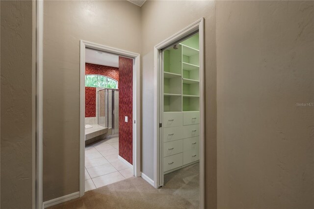 5119 NW 57th St, Gainesville, FL 32653 - hallway featuring light colored carpet, light tile patterned floors, and baseboards