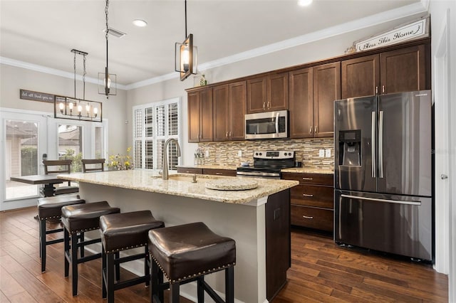 2898 SW 117th Way, Gainesville, FL 32608 - kitchen with appliances with stainless steel finishes, a sink, dark brown cabinets, decorative backsplash, and a kitchen bar