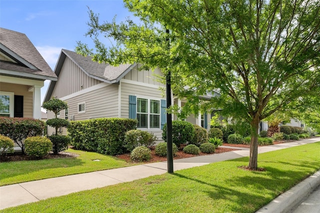 2898 SW 117th Way, Gainesville, FL 32608 - view of property exterior with a lawn, board and batten siding, and roof with shingles