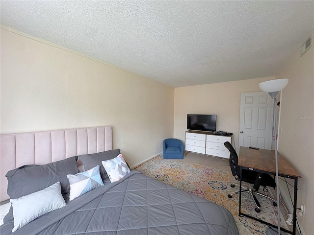 1700 SW 16th Ct Unit J22, Gainesville, FL 32608 - bedroom with carpet floors, a textured ceiling, and baseboards