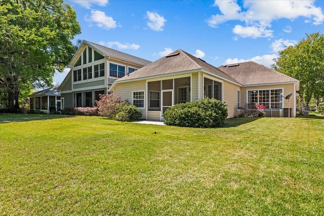 11737 Creek Dr, Alachua, FL 32615 - rear view of house featuring a sunroom, a lawn, and roof with shingles