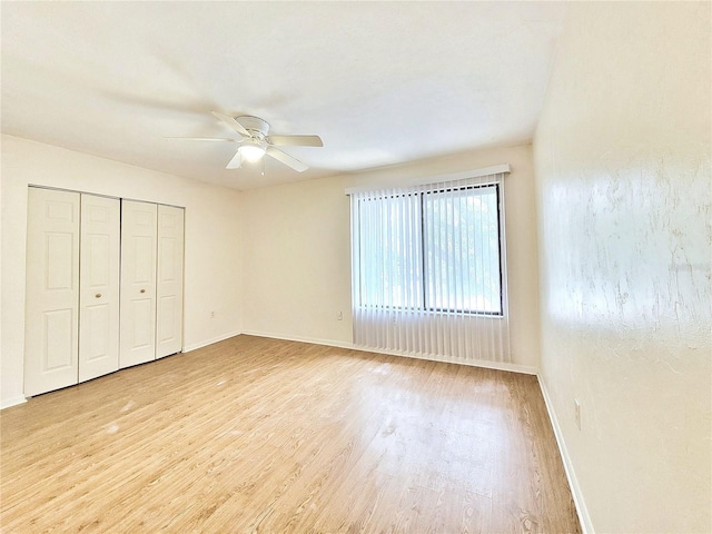 2300 SW 43rd St Unit L2, Gainesville, FL 32607 - unfurnished bedroom with wood finished floors, baseboards, a ceiling fan, and a closet