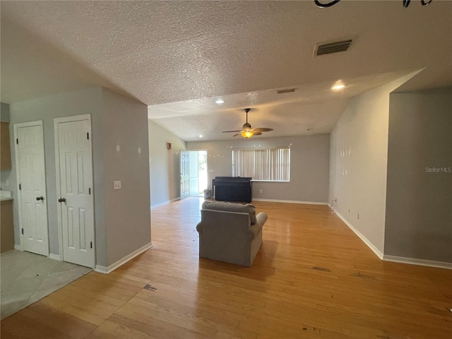 395 SW Grove St, Keystone Heights, FL 32656 - living area featuring light wood-style flooring, a textured ceiling, ceiling fan, and baseboards