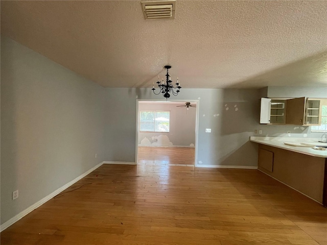 395 SW Grove St, Keystone Heights, FL 32656 - unfurnished dining area featuring a chandelier, light wood-style floors, a textured ceiling, baseboards, and ceiling fan