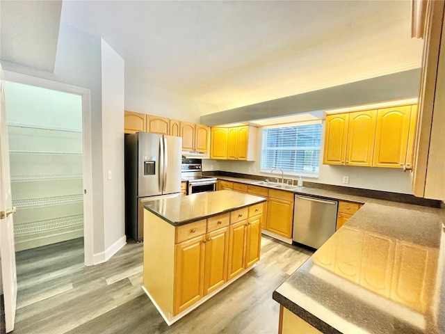 5510 NW 80th Ave, Gainesville, FL 32653 - kitchen featuring stainless steel appliances, a sink, light wood-style flooring, light brown cabinets, and a kitchen island