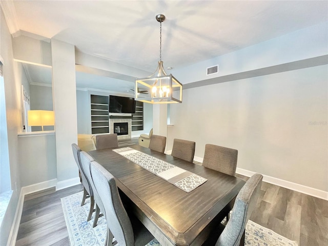 5510 NW 80th Ave, Gainesville, FL 32653 - dining room featuring baseboards, wood finished floors, a chandelier, and a tile fireplace