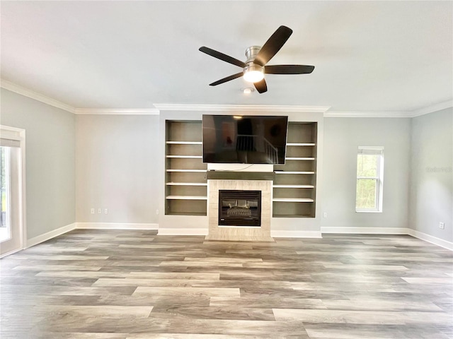 5510 NW 80th Ave, Gainesville, FL 32653 - unfurnished living room with wood finished floors, baseboards, ceiling fan, crown molding, and a tiled fireplace