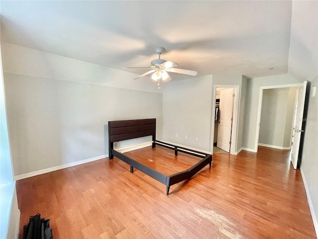 5510 NW 80th Ave, Gainesville, FL 32653 - unfurnished bedroom with wood finished floors, baseboards, a ceiling fan, and a walk in closet