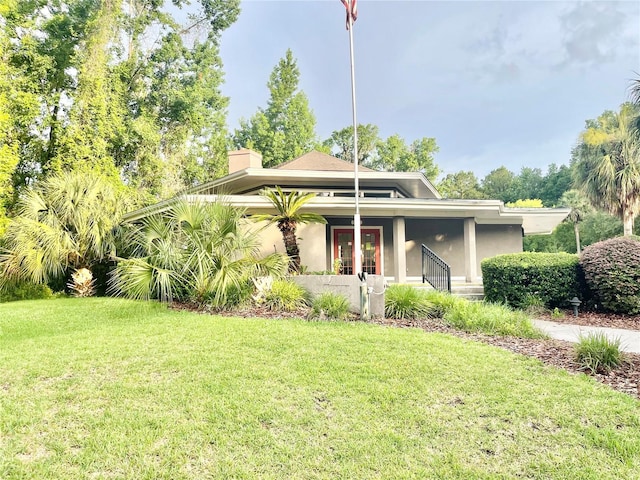 5510 NW 80th Ave, Gainesville, FL 32653 - view of front of property with a front yard, french doors, a chimney, and stucco siding