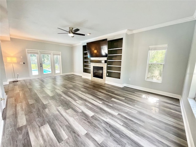 5510 NW 80th Ave, Gainesville, FL 32653 - unfurnished living room featuring ceiling fan, ornamental molding, wood finished floors, baseboards, and a glass covered fireplace