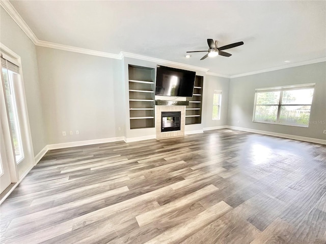 5510 NW 80th Ave, Gainesville, FL 32653 - unfurnished living room featuring crown molding, baseboards, ceiling fan, wood finished floors, and built in features