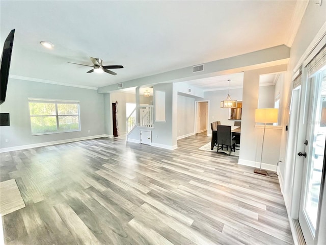 5510 NW 80th Ave, Gainesville, FL 32653 - unfurnished living room with baseboards, crown molding, light wood-style floors, stairs, and ceiling fan
