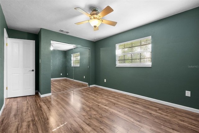 5806 NW 26th Ter, Gainesville, FL 32653 - unfurnished bedroom featuring wood finished floors, a closet, baseboards, and a ceiling fan