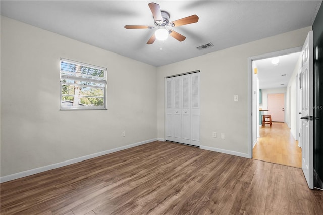 5806 NW 26th Ter, Gainesville, FL 32653 - unfurnished bedroom featuring wood finished floors, baseboards, a closet, and a ceiling fan