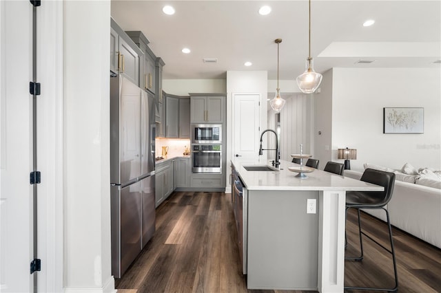 3225 SW 120th Ter, Gainesville, FL 32608 - kitchen featuring gray cabinetry, stainless steel appliances, a sink, a breakfast bar, and open floor plan
