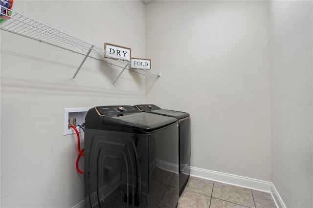 3225 SW 120th Ter, Gainesville, FL 32608 - washroom with washer and clothes dryer, baseboards, and light tile patterned floors