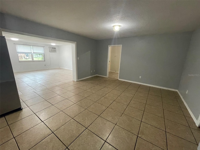 1702 NE 15th Ter, Gainesville, FL 32609 - unfurnished room with light tile patterned flooring, a textured ceiling, baseboards, and an AC wall unit