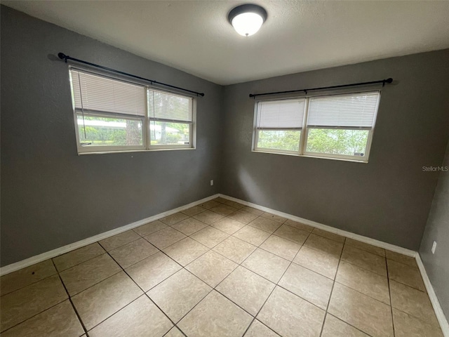 1702 NE 15th Ter, Gainesville, FL 32609 - spare room with light tile patterned floors and baseboards