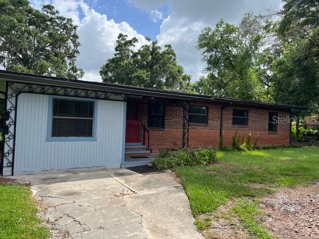 16431 NW US Highway 441, Alachua, FL 32615 - ranch-style house with entry steps, brick siding, and a front lawn