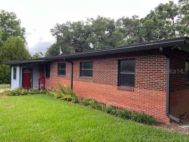 16431 NW US Highway 441, Alachua, FL 32615 - view of front facade featuring brick siding and a front yard