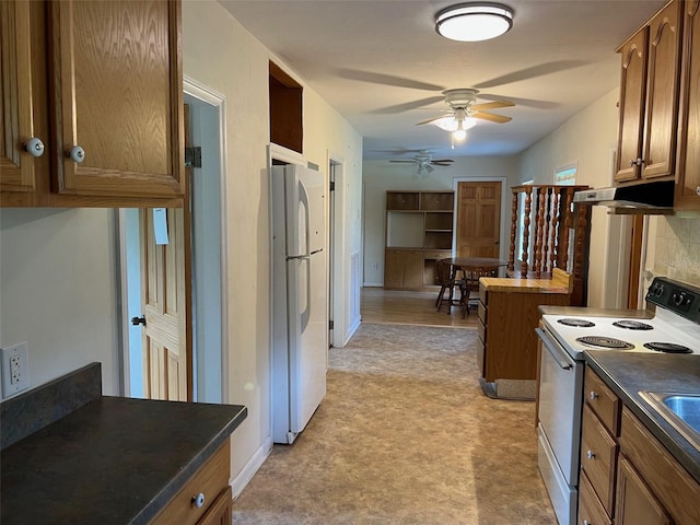 16431 NW US Highway 441, Alachua, FL 32615 - kitchen with white appliances, light flooring, a ceiling fan, brown cabinets, and under cabinet range hood