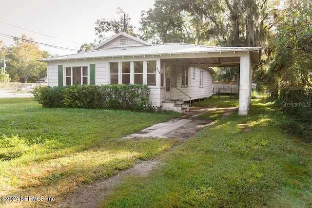 762 N Walnut St, Starke, FL 32091 - view of front of home with a front yard, metal roof, entry steps, and a carport