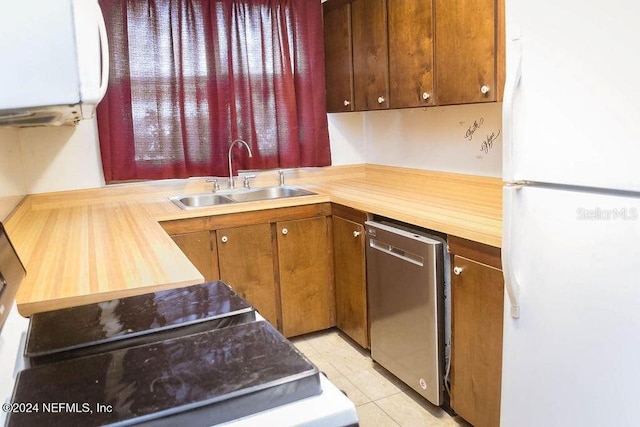 762 N Walnut St, Starke, FL 32091 - kitchen featuring freestanding refrigerator, stainless steel dishwasher, a sink, and light tile patterned flooring
