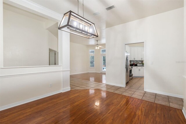 10303 SW 21st Ave, Gainesville, FL 32607 - spare room featuring tile patterned flooring, ceiling fan, baseboards, and a high ceiling
