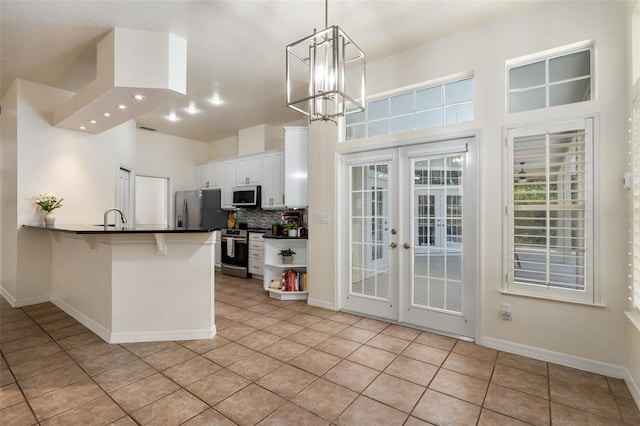 10303 SW 21st Ave, Gainesville, FL 32607 - kitchen featuring appliances with stainless steel finishes, french doors, dark countertops, white cabinets, and light tile patterned floors
